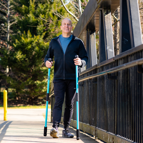 Older man walking with Jetti Fitness Poles on a bridge